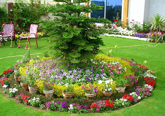 Round-Flower-bed-with-pots-around - Flower Bed Ideas